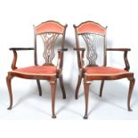 A pair of Edwardian open arm salon chair with upholstered seats and cabriole supports,