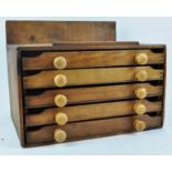A pine print block box with five drawers and turned handles,