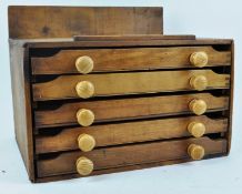 A pine print block box with five drawers and turned handles,