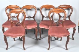 A set of six Victorian mahogany balloon back chairs on cabriole legs,