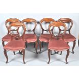 A set of six Victorian mahogany balloon back chairs on cabriole legs,