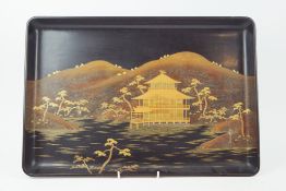 A Japanese lacquer tray, decorated with a pagoda in landscape, with gilt monogram to reverse, 48.