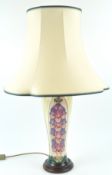 A Moorcroft table lamp, decorated with the foxglove pattern, on wooden base, the vase 36cm high,