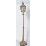 A bras standard lamp, with glass lantern shaped top,