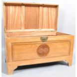 A Chinese camphor wood chest with carved top,