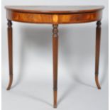 A 20th century mahogany demi lune side table with inlaid frieze, on reeded turned legs,