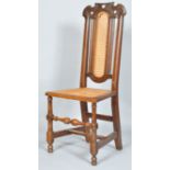 A 19th century oak chair with 18th century crest, caned back and seat,