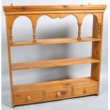 A late 20th century pine hanging three tier wall shelf with three drawers,