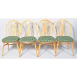 A set of Ercol beech and elm feather back dining chairs in the blonde colourway each with pad seat.