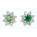 A yellow and white metal pair of emerald and cubic zirconia cluster stud earrings.