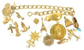 A yellow metal curb link bracelet having four fixed charms and fourteen assorted loose charms.