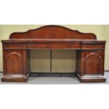 A late 19th century Victorian mahogany sideboard having a shaped back with threefrieze drawers