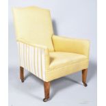 An Edwardian upholstered easy chair, on square tripod front supports,