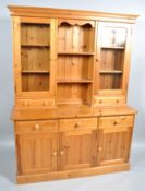 A pine dresser, the upper section with glazed door cupboard, drawers and shelves,