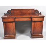 A Victorian mahogany pedestal sideboard with carved raised back above on inverted break front with