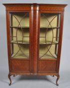 An Edwardian inlaid mahogany display cabinet, on cabriole supports,