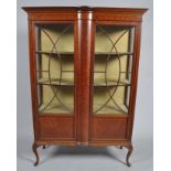 An Edwardian inlaid mahogany display cabinet, on cabriole supports,