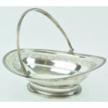 A Sheffield plate cake basket, of oval form with a ribbed swing handle and ribbed edge,