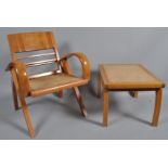 A 20th century folding armchair with caned seat, together with a matching footstool,