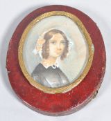 A miniature of a young lady in a brass frame in older miniature frame
