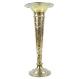 A silver trumpet vase with flared lip over a split hammered body, on a plain loaded foot,