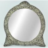 A silver mounted strut back dressing table mirror, of round form,