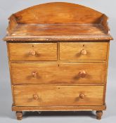 A Victorian pine chest with raised back above two short and two long drawers on turned legs, 106.