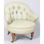 A Victorian tub shaped nursing chair with button back, on turned legs with brass casters,