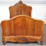 A 20th century French walnut bed frame, scroll carved top rail with headboard,
