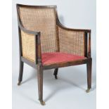 A Regency style bergere armchair, with upholstered seat, square tapering legs and brass casters,