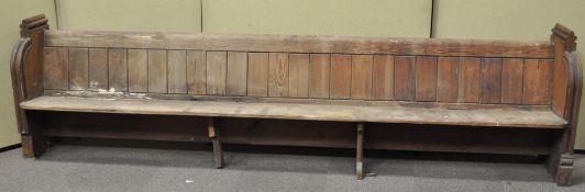 A Victorian pine pew, one end carved with a quatrefoil,