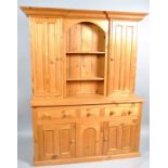 A two section pine dresser, the upper section with central shelf flanked by cupboard doors,