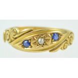 A yellow metal three stone ring set with sapphires and diamonds.