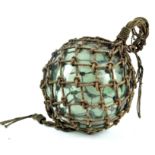 A large 19th century blown glass fishing float, in rope surround,