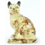 A Staffordshire creamware model of a seated cat of Whieldon type, enriched in a tortoishell glaze,