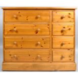 A 20th century pine chest of four short and four long drawers on plinth base,