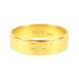 A yellow metal flat profile wedding ring, 5.20mm. Hallmarked 22ct gold, London, 1964. Size O. 4.