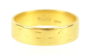 A yellow metal flat profile wedding ring, 5.20mm. Hallmarked 22ct gold, London, 1964. Size O. 4.