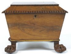 A William IV mahogany cellarette, of sarcophagus form, on carved paw feet, enclosing brass casters,