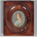 An oval miniature portrait of a lady, half-turned,