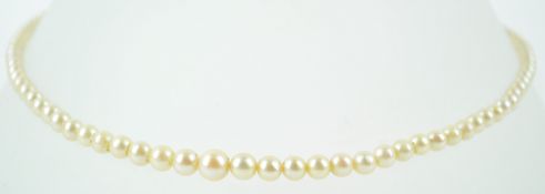 A tie pin set with a 8mm white cultured pearl together with a single strand of graduated simulated