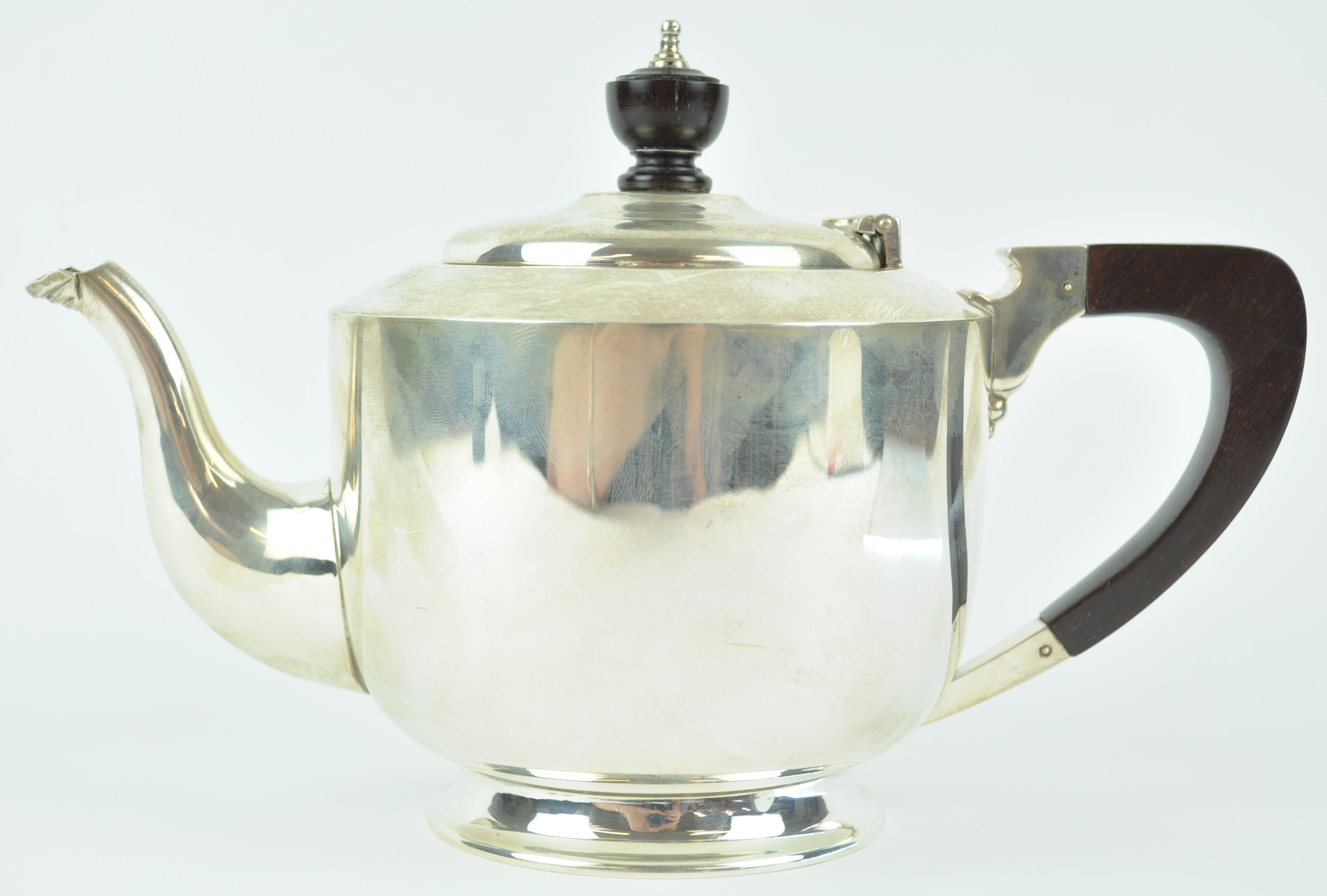A silver teapot, of very plain cylindrical form with domed cover, on a flared foot,