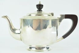 A silver teapot, of very plain cylindrical form with domed cover, on a flared foot,