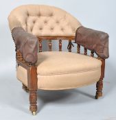 A Victorian button back armchair, with turned uprights,