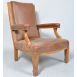 An Edwardian oak framed smokers chair, in brown rexine upholstery, 99cm high x 67.