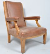 An Edwardian oak framed smokers chair, in brown rexine upholstery, 99cm high x 67.