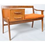 A 1960's retro vintage teak wood telephone table, with two drawers and adjacent seat,