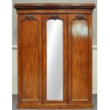 A Victorian mahogany wardrobe with two panelled doors and a mirrored door,