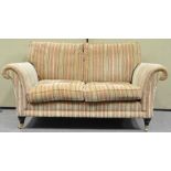 A Parker Knoll two seat sofa with loose cushions, on turned legs with brass casters,