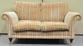 A Parker Knoll two seat sofa with loose cushions, on turned legs with brass casters,